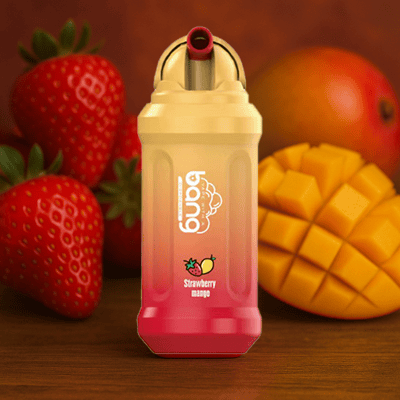 Butelka napoju marki Buba o smaku truskawkowo-mango, umieszczona przed świeżymi truskawkami i pokrojonym mango na drewnianej powierzchni.