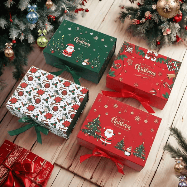 Colorful Christmas gift boxes with festive designs, including Santa Claus and evergreen trees, sit on a wooden floor under a decorated Christmas tree, each wrapped with red or green ribbons.